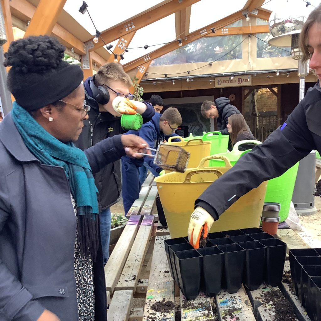 School students, filling plant pots with compost.
