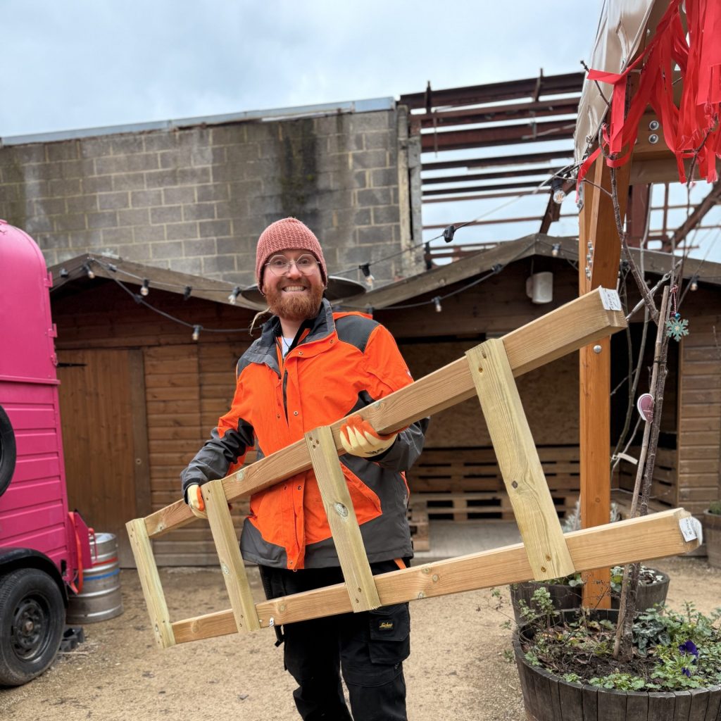 Worker carrying part of a seedling stand.