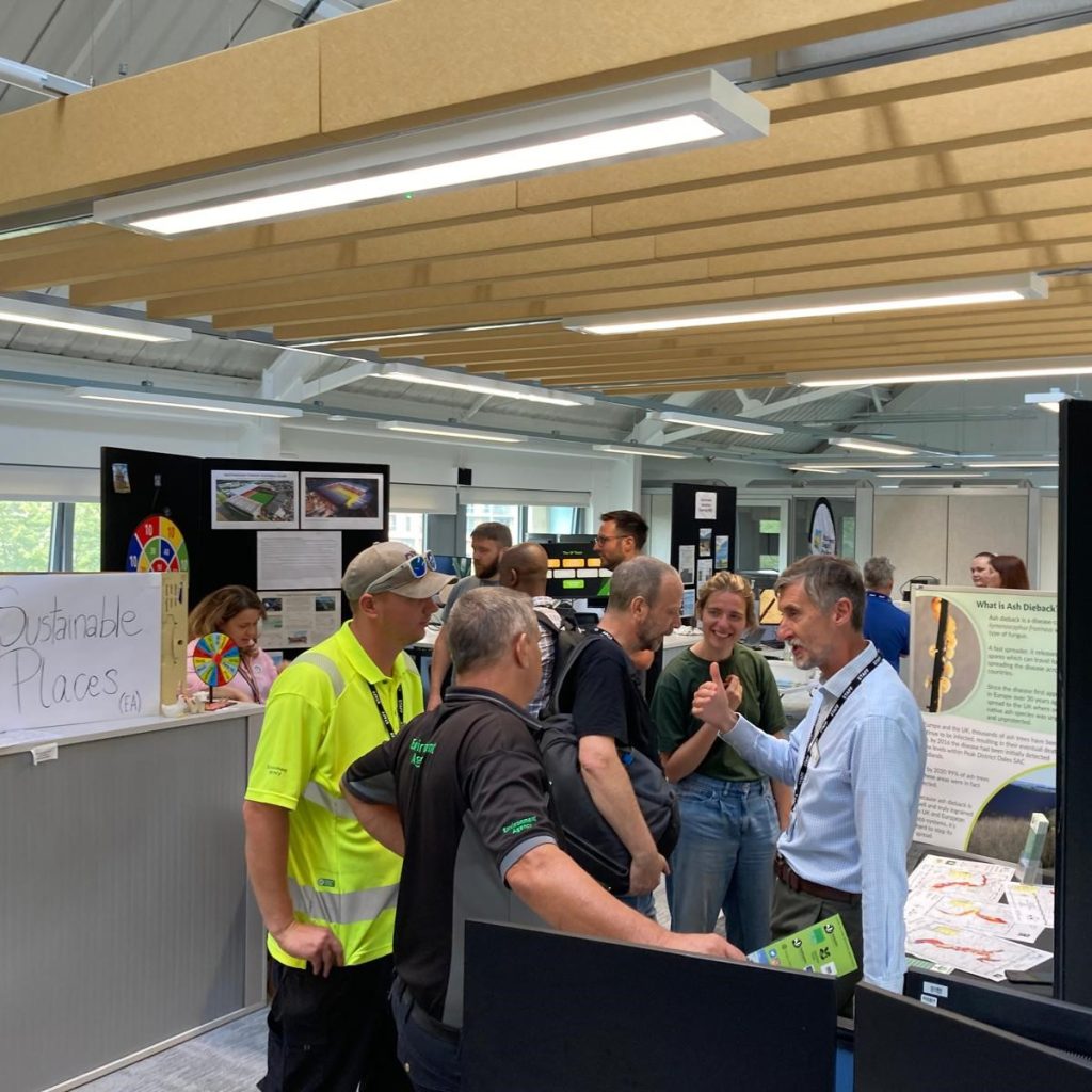 People talking around a display stand at a conference.